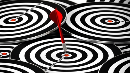 red dart hitting the center of a dartboard, there is may other targets around itの写真素材