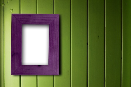 empty purple frame fixed on a green wooden wall, the color of the inner part of the frame is whiteの写真素材