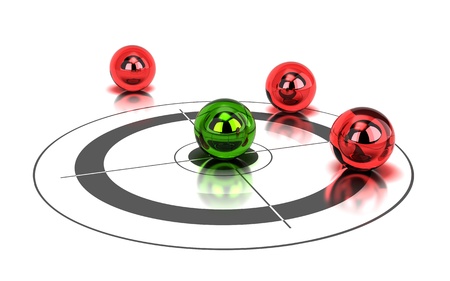 one green ball hitting the center of a target and tree red balls around it - image is over a white backgroundの写真素材