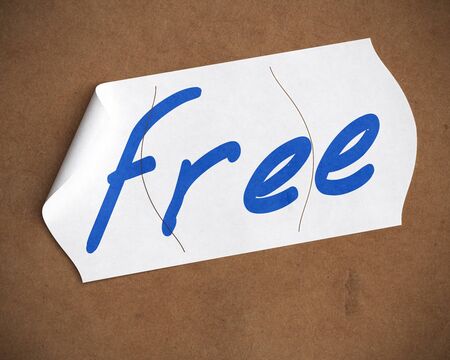free word hanwritten onto a tearable price tag over a cardboard background, blue color text, white label and brown cartonの写真素材