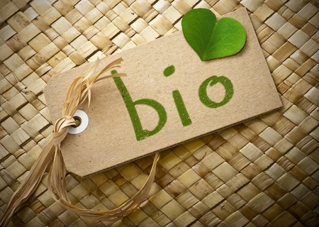 Natual cardboard label with the word bio handwritten on it plus a green clover petal の写真素材