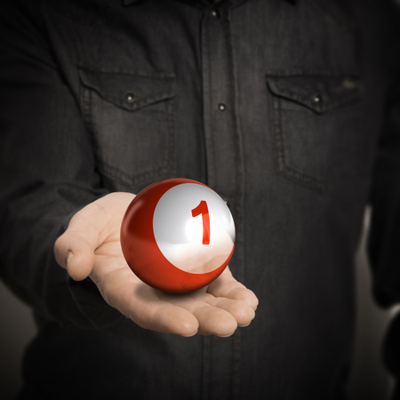 Man hand holding red ball with number one over blackbackground, concept image for illustration of leader.の写真素材