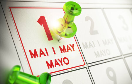 Thumbtack pointing the first of may on a calendarの写真素材