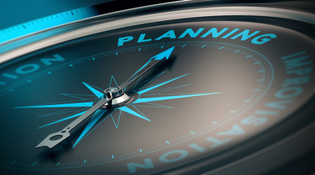 Compass with needle pointing the word planning, concept image to illustrate business plan and strategy.