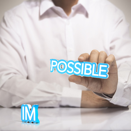 One man holding the word possible in one hand with  the prefixの写真素材