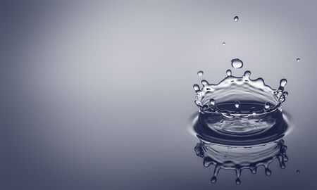 Water drip splashing a clear blue background with reflexion and room for your text.