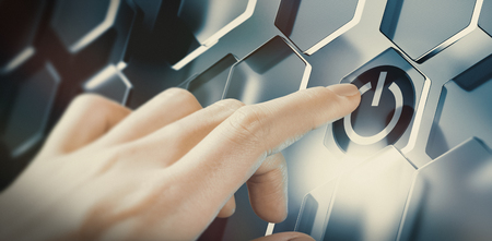 Finger pushing digital start button on a futuristic interface. Conceptual design of an innovative technology. Composite image between a hand photography and a 3D background.の写真素材