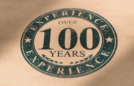 Composite Image between a stamp drawing and a brown paper photography. Rubber stamp label of a very old company with over 100 years of experience. Concept of business longevity.の写真素材