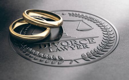 3D illustration of two used golden rings over a divorce lawyer sign unbossed on a black paper.の写真素材
