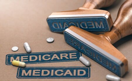 3D illustration of two rubber stamps with the words Mercicare and Medicaid over paper background.の写真素材