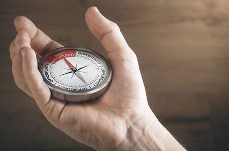 Man hand showing compass with needle pointing the text best opportunity. Concept image to illustrate business or career opportunities.の写真素材