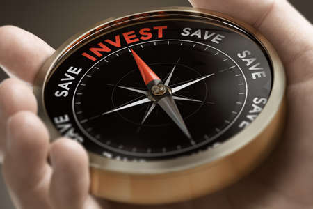 Hand holding a conceptual compass with the words invest or save. Investing strategy concept....
