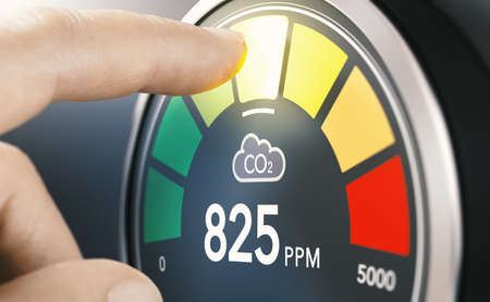 Finger touching digital screen of a CO2 monitor to measure indoor air quality and carbon dioxide concentration.の写真素材