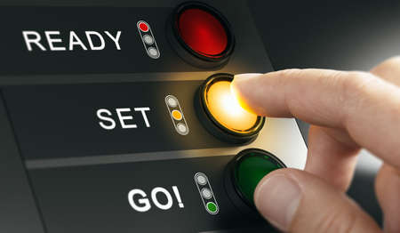 Man pressing countdown buttons on a board to start an event or a race. Composite image between a hand photography and a 3D background.の写真素材