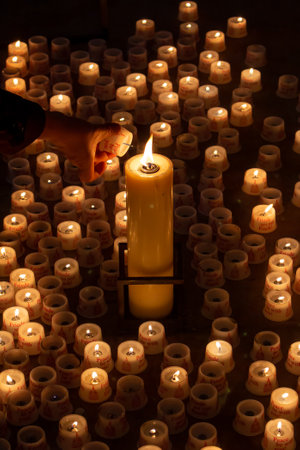 A person lighting a candle in churchの写真素材