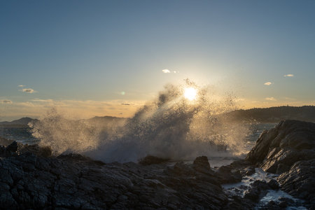Waves crashing on cliffs at sunset