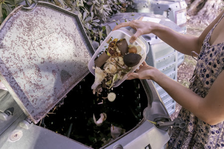 A woman throws compost in the binの写真素材