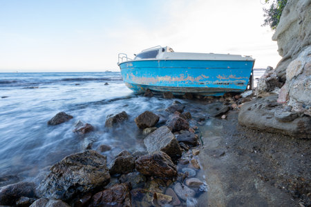 Boat at sunset, waves on the seaの写真素材