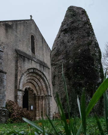 A menhir in front of a churchの写真素材