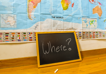 A chalk board with where written on and a world mapの写真素材