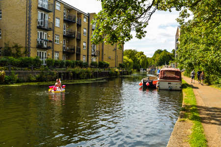 London/UK - 9/8/20 - A group of friends playing on inflatables in the canalのeditorial素材