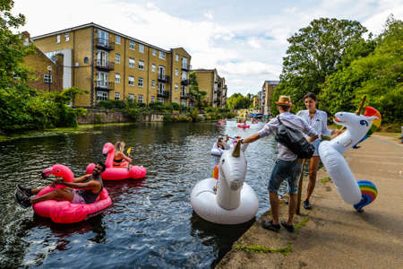 London/UK - 9/8/20 - A group of friends playing on inflatables in the canalのeditorial素材
