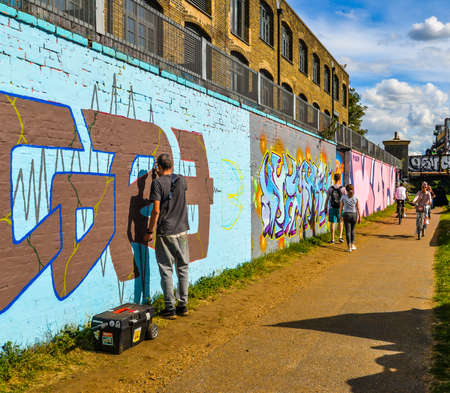 London/UK - 9/8/20 - Artist working on a mural next to a canalのeditorial素材