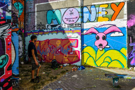 London/UK - 9/8/20 - Artist working on a mural next to a canal