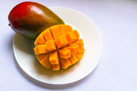 Ripe mango diced on a white plate.の写真素材