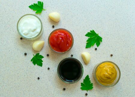 A set of sauces and specials. Indian cuisine Pepper, garlic, paprika, curry, basil, mustard, nutmeg, turmeric. View from above. Close-up.の写真素材
