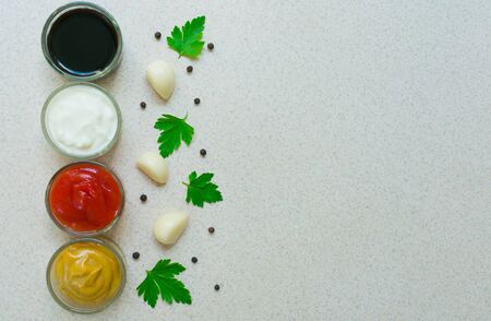 A set of sauces and specials. Pepper, garlic, paprika, curry, parsley, basil, mustard, nutmeg, turmeric. View from above. Close-up. Copy space.の写真素材