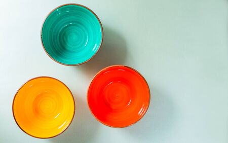 Empty ceramic colored bowls on a gray background. View from the top.Copy space.の写真素材