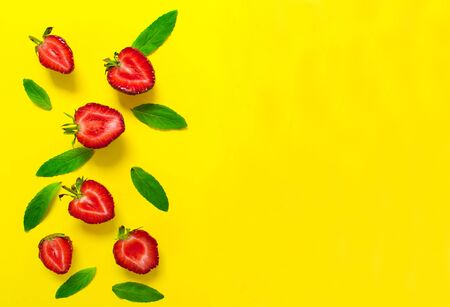Strawberries and mint leaves on a bright yellow background. Background for the design of banners, websites, blogs. Copy spaceの写真素材