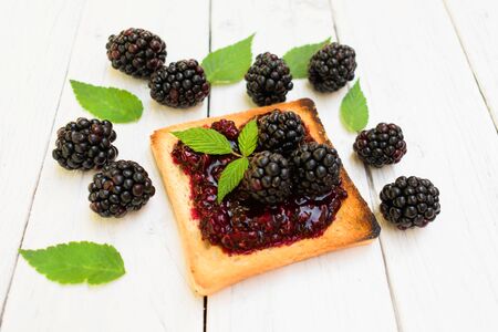 Toaster with blackberry jam. Decorated with fresh berries and blackberry leaves.の写真素材