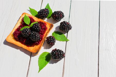 Toaster with blackberry jam. Decorated with fresh berries and blackberry leaves.の写真素材