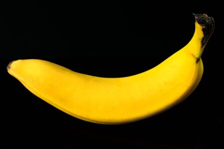 One banana isolated on black backgroundの写真素材