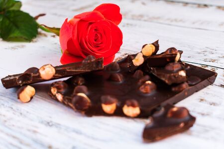 Red rose and black chocolate with hazelnuts