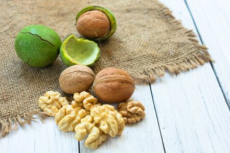 Inshell walnuts and walnut kernels on a white wooden table. The concept of a healthy diet.の写真素材