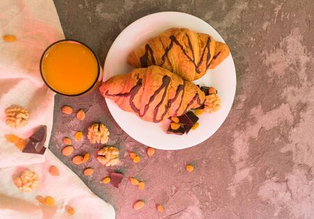 Tasty breakfast. Chocolate croissant nuts, raisins and a glass of fresh orange juice. Top viewの写真素材