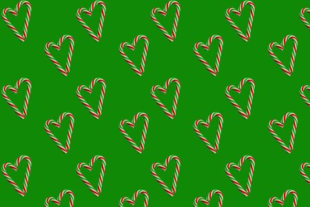 Little hearts from christmas candies on a green background. Seamless wrapping paper concept, wallpaper, pattern for fabric.の写真素材