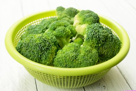 Broccoli cabbage in a plate on a white wooden backgroundの写真素材