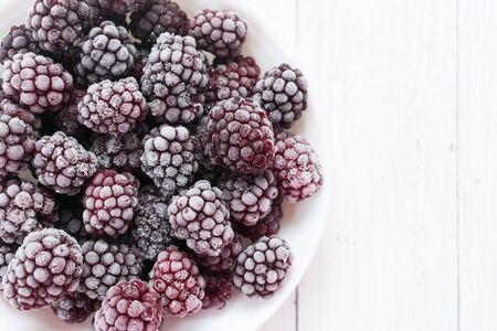 Frozen blackberries on a white background. Top view. Copy space.