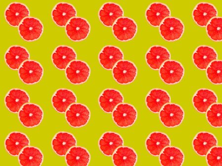 Seamless photo pattern of grapefruit slices on a yellow background. Seamless pattern for your design.の写真素材