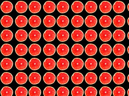 Seamless photo pattern of grapefruit slices on a black background. Seamless pattern for your design.