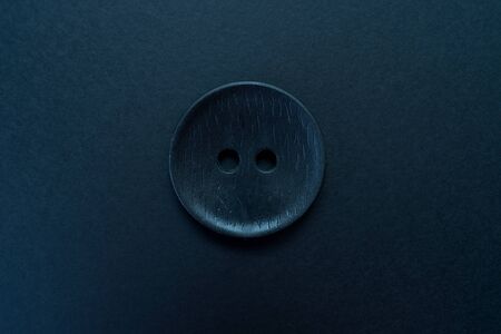Big black button isolated on a black background.
