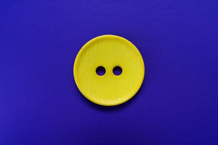 Big yellow button isolated on a blue background.
