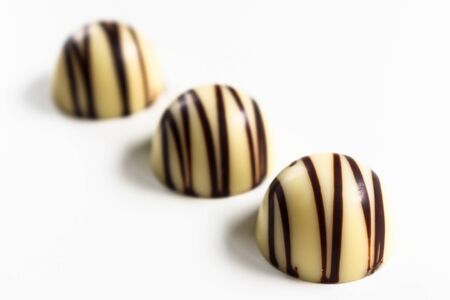Three white chocolate candies isolated on a white background.の写真素材