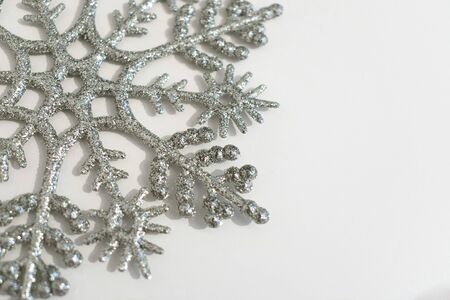 Christmas background. Big silver snowflake on a white background. Copy space. Minimalistic design.