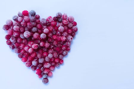 Heart made from berries of frozen cranberries on a white background. Copy space.の写真素材