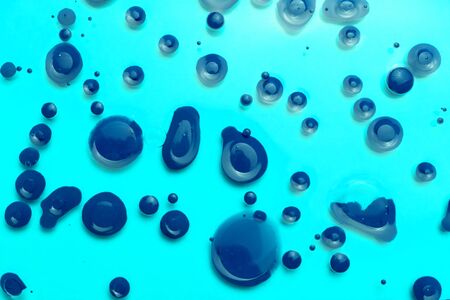 Abstract background of a drop of blue paint on a blue background.